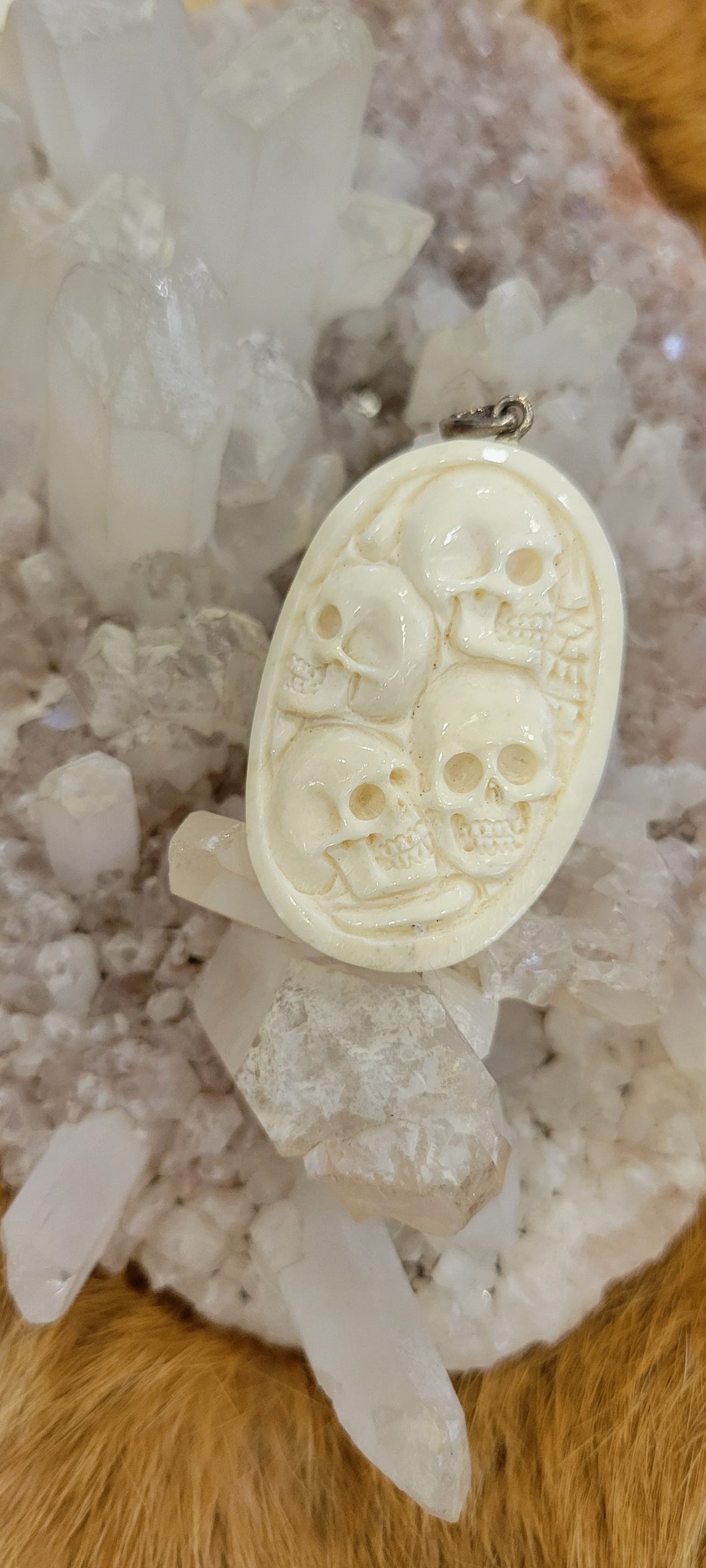 Bone carved 4 skull pendant